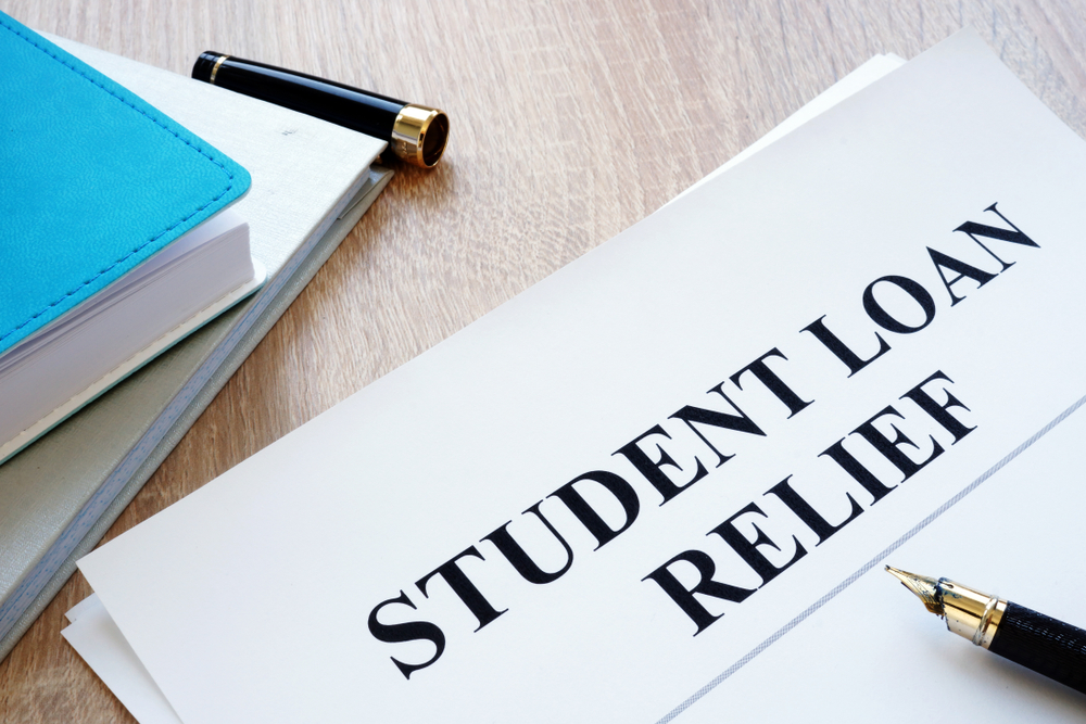 A person filling out a loan forgiveness application form to receive forgiveness under the save plan or income driven repayment plan or debt relief plan for the remaining balance for student debt relief from monthly payment and direct loans 